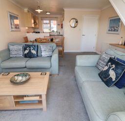 A living room with a coffee table and sofas at Daisy Lodge in Norwich