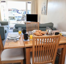 A dining area with a table set for breakfast at Daisy Lodge in Norwich