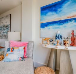 A corner of a room with a chaise lounge and decorative items on a console table at Stargazers in Sennen
