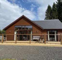 A log cabin with decking and seating area at Burnside Lodge (Lodge 1, Glengoulandie) Aberfeldy