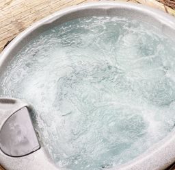 A bubbling hot tub on a wooden deck at 4 Stonerush Valley in Lanreath