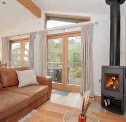 A living room with a fireplace and sofa at 2 Streamside in Lanreath