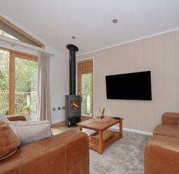 A living room with a stove and sofa at 2 Streamside in Lanreath