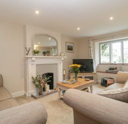 A living room with sofas a coffee table and a fireplace with a mirror above at Market House in Abbotsbury