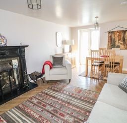 A living room with a fireplace sofa armchair dining table and chairs at Cranny Corner in Carnlough
