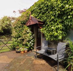 An outdoor area with chairs and a table near a door at Holemire Barn in Lorton