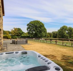 An outdoor area with a hot tub and seating at Ty Berllan in Caersws