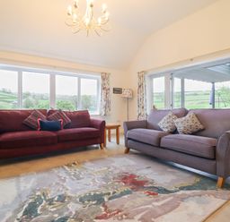 A living room with two sofas and a patterned rug at Ochr Y Garth in Maenan