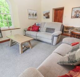 A living room with two sofas a wooden coffee table and plaid curtains at Beggars Roost in Penhallow