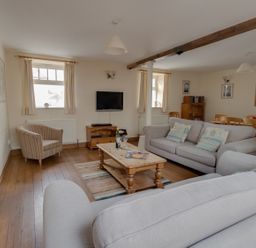 A living room with sofas a wooden coffee table a television and a dining table at Georges House in Brewers Quay Harbour