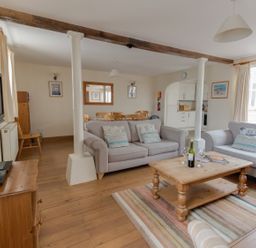 A living room with two sofas a wooden coffee table a dining area and kitchen at George's House in Brewers Quay Harbour