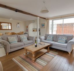 A living room with two sofas and a wooden coffee table on a striped rug at Georges House Brewers Quay Harbour