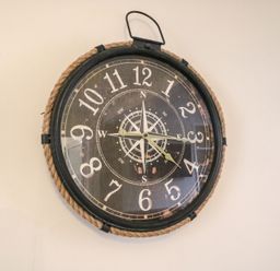 A round wall clock with rope border and compass design at Guinea Cottage in Brewers Quay Harbour