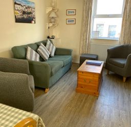 A living room with a sofa and armchairs at Guinea Cottage in Brewers Quay Harbour
