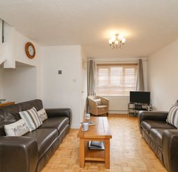 A living room with two dark sofas a wooden coffee table and a small television at Home Waters in Wyke Regis