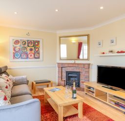 A living room with a sofa table lamp fireplace and television at Hops House in Brewers Quay Harbour