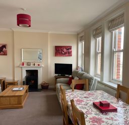 A living room with a sofa and dining table at Mutiny House in Brewers Quay Harbour