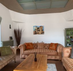 A living room with sofas, a coffee table, and a bookshelf at The Oast House in Brewers Quay Harbour