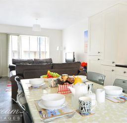 A dining table set with bowls mugs and fruit in a kitchen living room area at Olympic Cottage in Portland