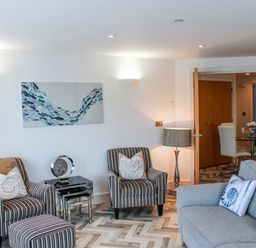 A living room with armchairs and a coffee table at Estuary View in Kingsbridge