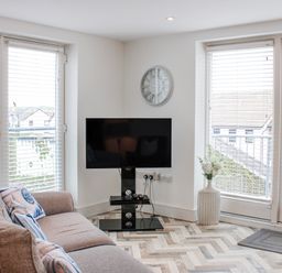 A living room with a television and a sofa at Estuary View in Kingsbridge