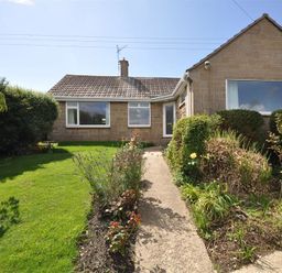 A single story house with a tiled roof and garden with a pathway at Pebbles in Burton Bradstock