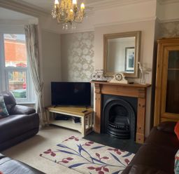 A living room with a television and sofa at Pedaller's Cottage in Weymouth