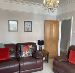 A living room with a sofa and armchair at Pedaller's Cottage in Weymouth