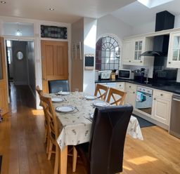 A kitchen featuring a dining table and appliances at Pedaller's Cottage in Weymouth
