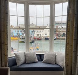 A window with cushions overlooking the harbor at Safe Harbour Brewers Quay harbour