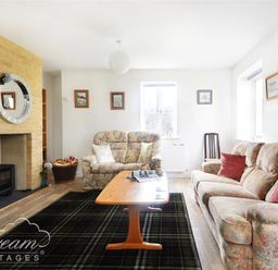 A living room with floral sofas a wooden coffee table a fireplace and framed pictures on walls at St Johns View in Portland