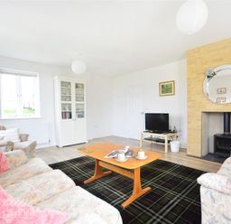 A living room with a fireplace a TV on a small table sofas and a wooden coffee table at St Johns View in Portland