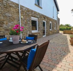 An outdoor area with a table and chairs at Tides Corner in Bowleaze