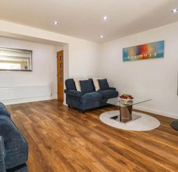 A living room with a sofa and a coffee table at Tides Corner in Bowleaze