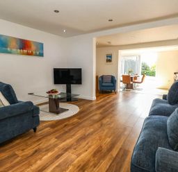 A living room with furniture and a view to the dining area at Tides Corner in Bowleaze