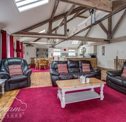 A living room with leather sofas coffee table dining table and wooden beams at Upsidedown House Brewers Quay Harbour