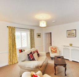 A living room with sofas a coffee table and yellow curtains at Warmwell Lodge in Warmwell