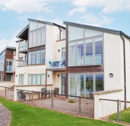 A building with balconies and grass at 2 Ocean's Edge Thurlestone