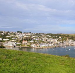 A coastal town with houses along a bay and green fields in the foreground at Bow Cottage in East Portlemouth