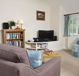 A living room with a sofa a bookshelf a television a chessboard and a bean bag at Cloverwell in Woodleigh
