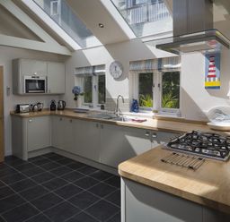 A kitchen with a wooden countertop gas stove and skylights at Gooder House in Dartmouth