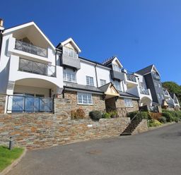 A multi-story residential building with balconies and stone lower walls at The Hoot 16 St Elmo Court in Salcombe