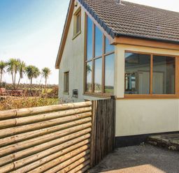 A house with a fence and palm trees at The Station in Bolberry