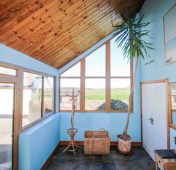 An entrance hall with a coat rack and plant at The Station in Bolberry