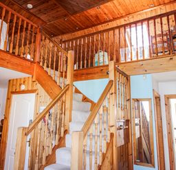 A hallway with a staircase and wooden railings at The Station in Bolberry