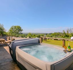 An outdoor space with a hot tub and table at Mellydonen Beder Del (Melly), Tor Down Quarry, St Breward