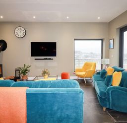 A living room with a sofa and armchair at Postcard Lodge in Polruan
