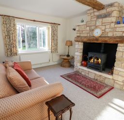 A living room with a sofa a fireplace and a window with curtains at The Hideaway in Eckington