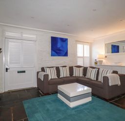 A living room with a sofa and coffee table at Rock House in Trebarwith Strand near Tintagel