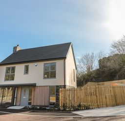 A two story house with a pitched roof and a wooden fence in a suburban area at High Tide House in Craster